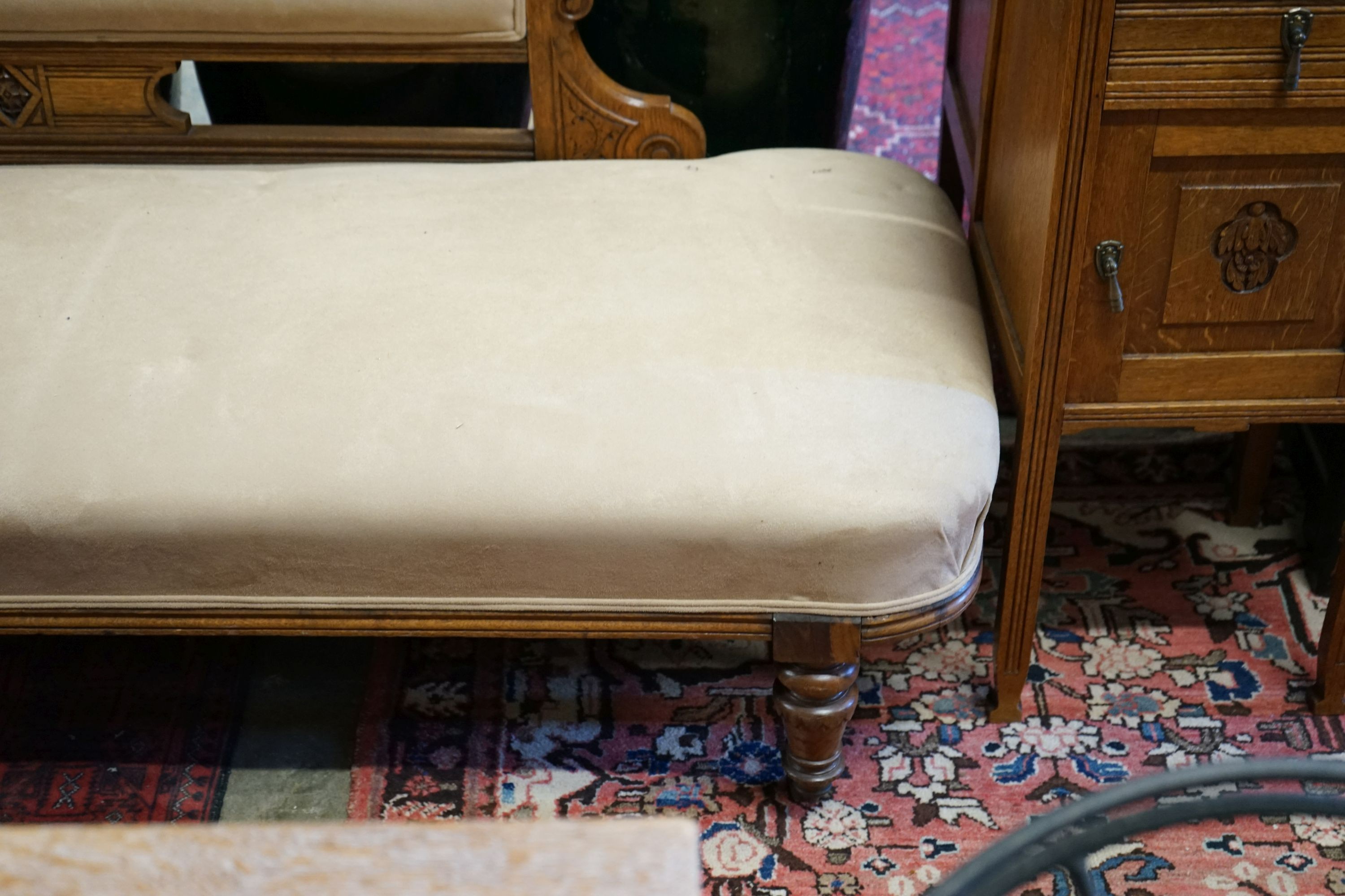 A late Victorian carved oak chaise longue upholstered in fawn suede, length 180cm, depth 70cm, height 79cm